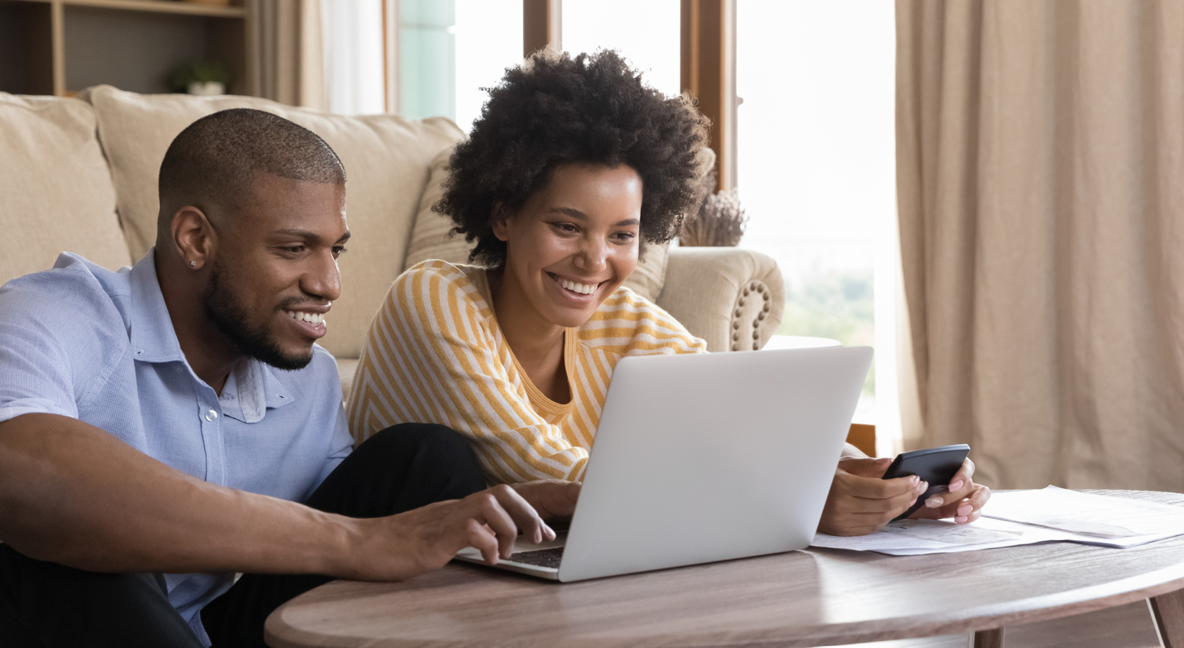 Couple looking happily at a laptop